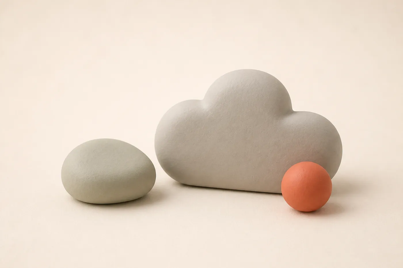 Ein ruhiger Ton-Kiesel neben einer weichen Blob-Wolke und einer kleinen Kugel als stimmungsgebendes Auflockerungs-Motiv nach den beiden Tabellen-Abschnitten.