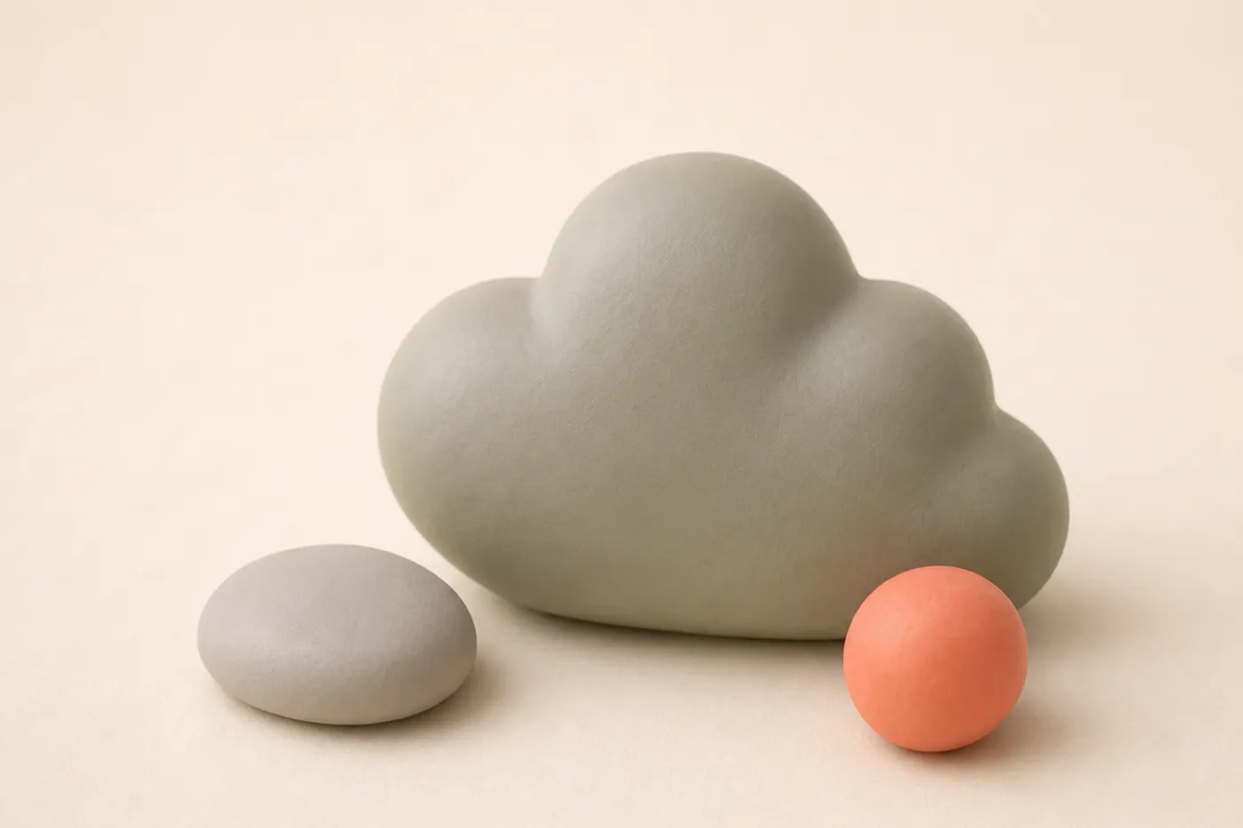 Eine ruhige Ton-Blob-Wolke neben einem Kiesel und einer kleinen Kugel als stimmungsgebendes Auflockerungs-Motiv nach dem Google-Ads-Abschnitt.