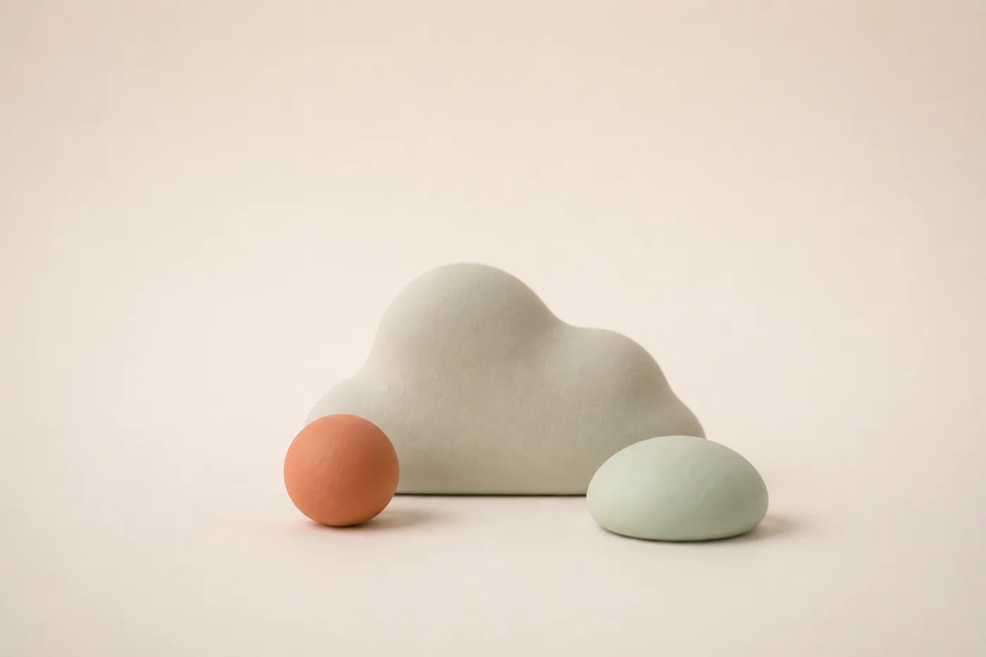 Ein ruhiger Ton-Kiesel neben einer weichen Blob-Wolke und einer kleinen Kugel als stimmungsgebendes Auflockerungs-Motiv nach dem Kostenfallen-Abschnitt.